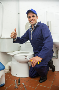 image of plumber repairing a toilet